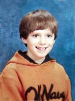 Lanza smiling wearing an Orange Hoodie for his yearbook photo in 6th Grade at Reed Intermediate School around 2004.
